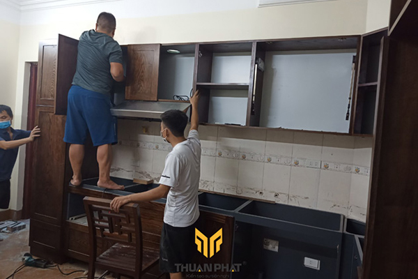 Đội ngũ thi công đang lắp đặt một bộ tủ bếp Inox sơn tĩnh điện cánh gỗ Sồi Nga sơn màu Óc Chó
