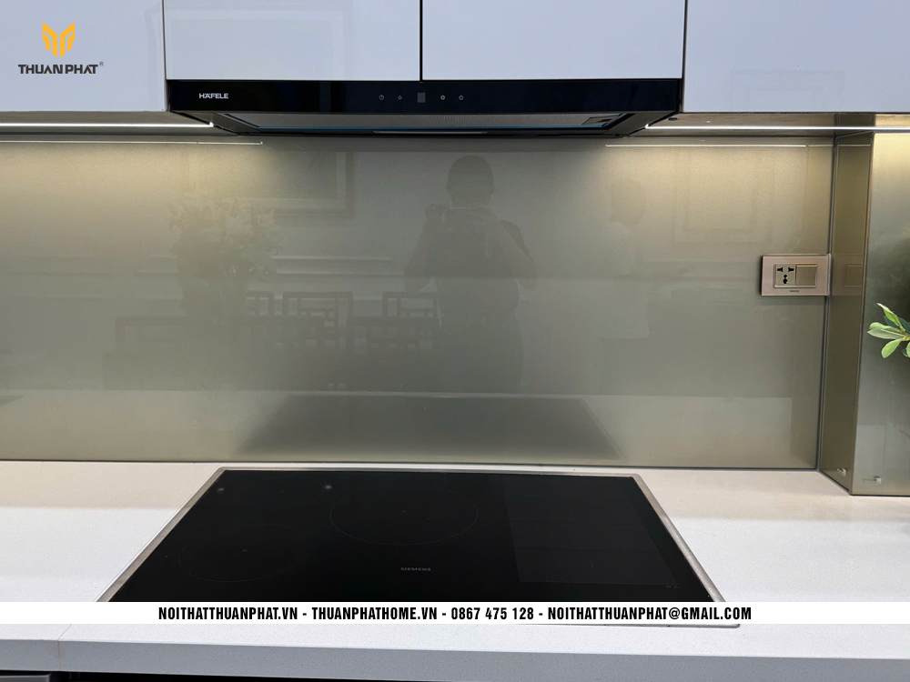 Bếp từ và máy hút mùi âm tủ trong công trình tủ bếp inox cánh Acrylic nhà chị Loan